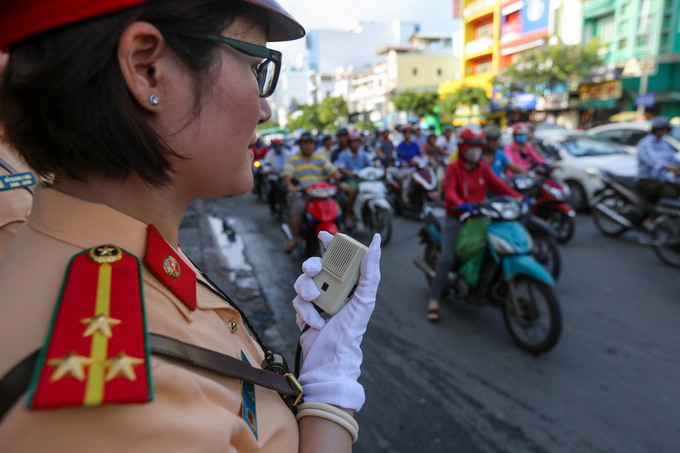 Nữ CSGT cầm loa điều tiết giao thông ở TP HCM
