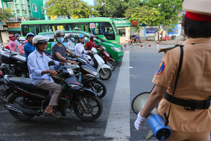 Nữ CSGT cầm loa điều tiết giao thông ở TP HCM