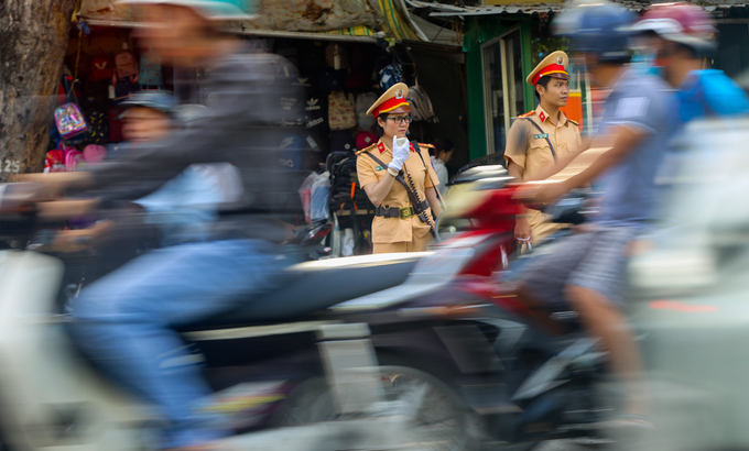 Nữ CSGT cầm loa điều tiết giao thông ở TP HCM