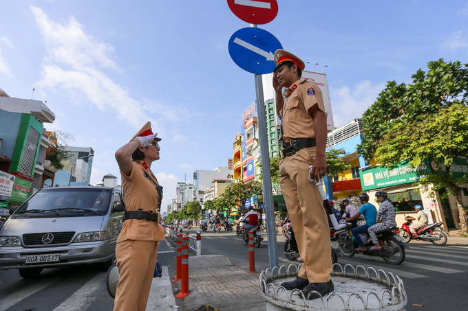 Nữ CSGT cầm loa điều tiết giao thông ở TP HCM